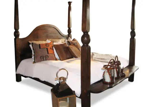 Four-poster bed with decorative pillows and lanterns.