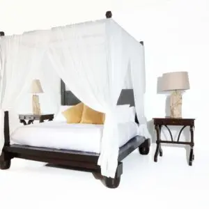 A bed with white sheets and pillows on it.