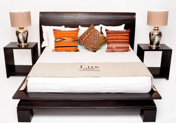 Stylish bed with decorative pillows and lamps.