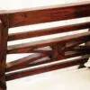 Carved wooden bench back with cushion.