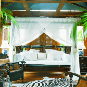Canopy bed with zebra print rug.