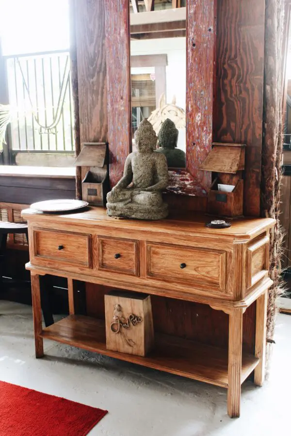 Wooden console table with Buddha statue.