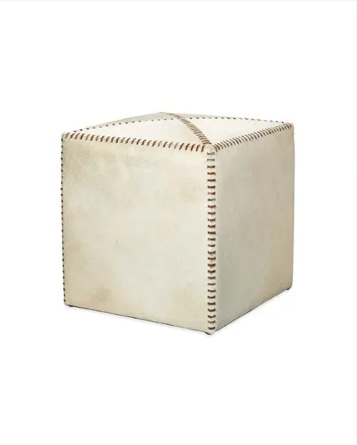 White leather ottoman with brown stitching.