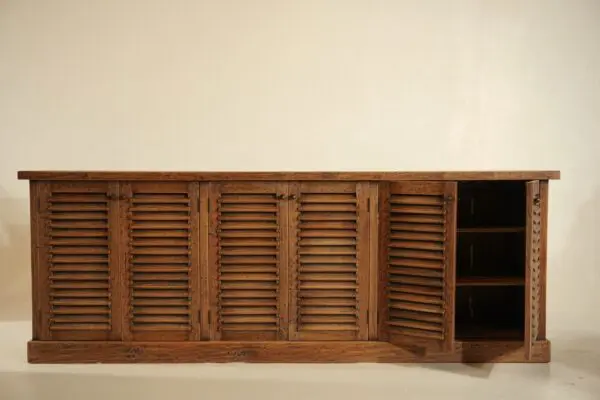 Wooden cabinet with slatted doors opened.