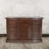 Wooden cabinet with three louvered doors.