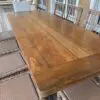A large wooden table with two chairs on top of it.