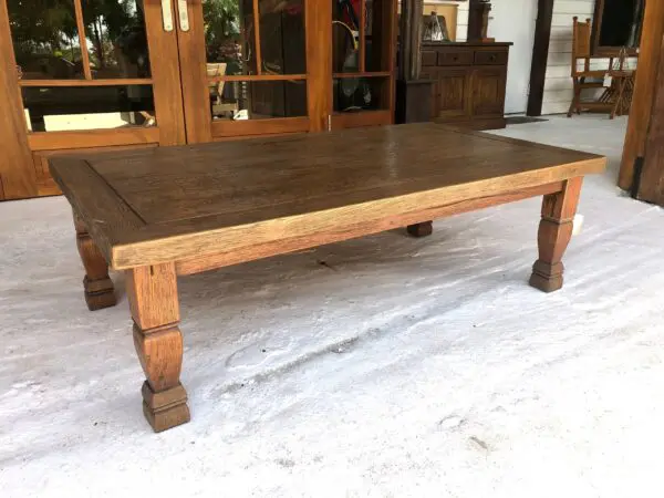 A large wooden table sitting in front of two doors.