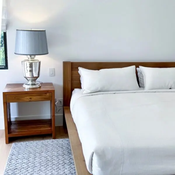 Modern bedroom with lamp and wooden furniture.