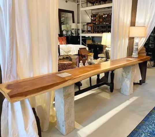 A long table with two pillars and wooden top.