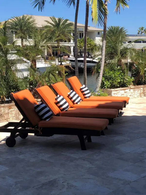 Orange lounge chairs by tropical scenery.