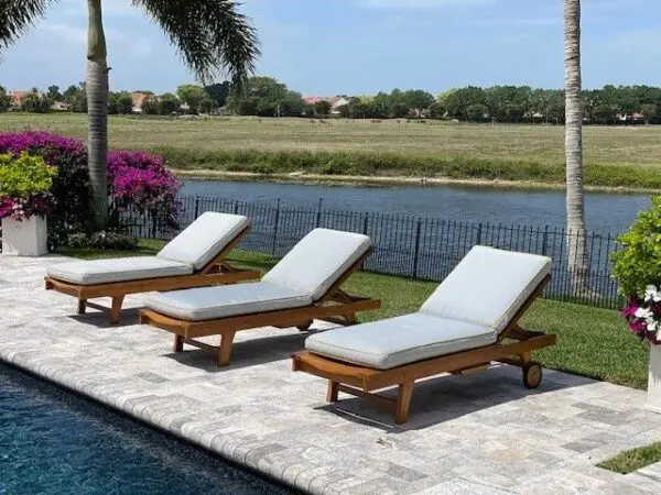 Poolside lounge chairs by a scenic view.