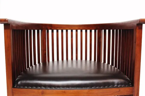 A wooden bench with black leather seat cushion.