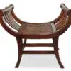 Wooden bench with curved design and cane seating.