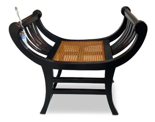 Wooden bench with curved back and cane seat.