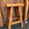 Wooden stool against a bamboo backdrop.