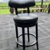 Black bar stool on a wooden deck.