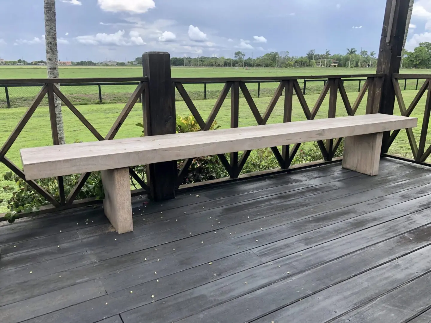 A wooden bench on the side of a deck.