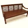 Wooden bench with decorative backrest design.