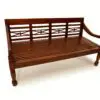 Wooden bench with decorative backrest design.