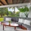 A couch and table in the middle of an outdoor room.