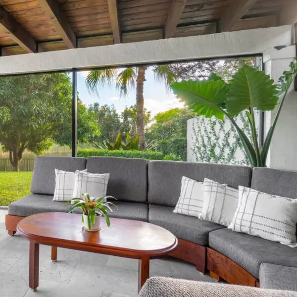 A couch and table in the middle of an outdoor room.