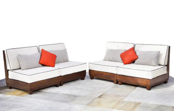 Two couches with pillows on a tile floor.