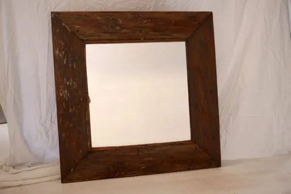 Rustic wooden mirror against a white background.