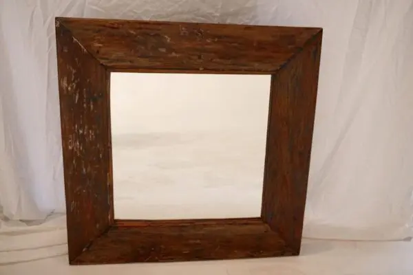 Wooden framed mirror with rustic appearance.