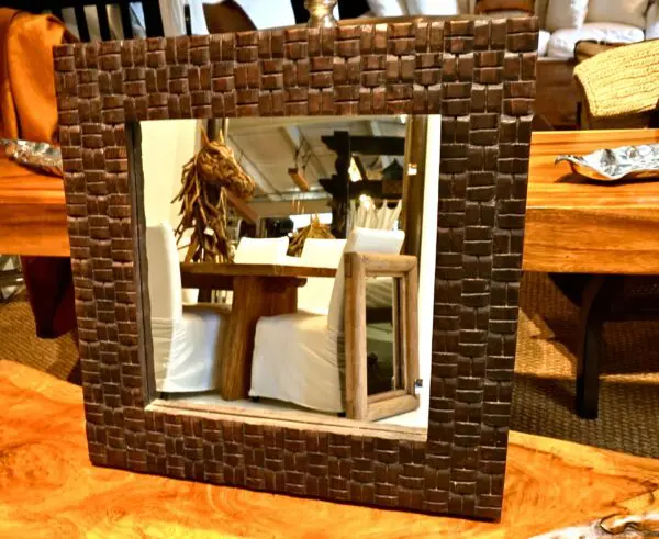 Decorative mirror with wooden frame design.