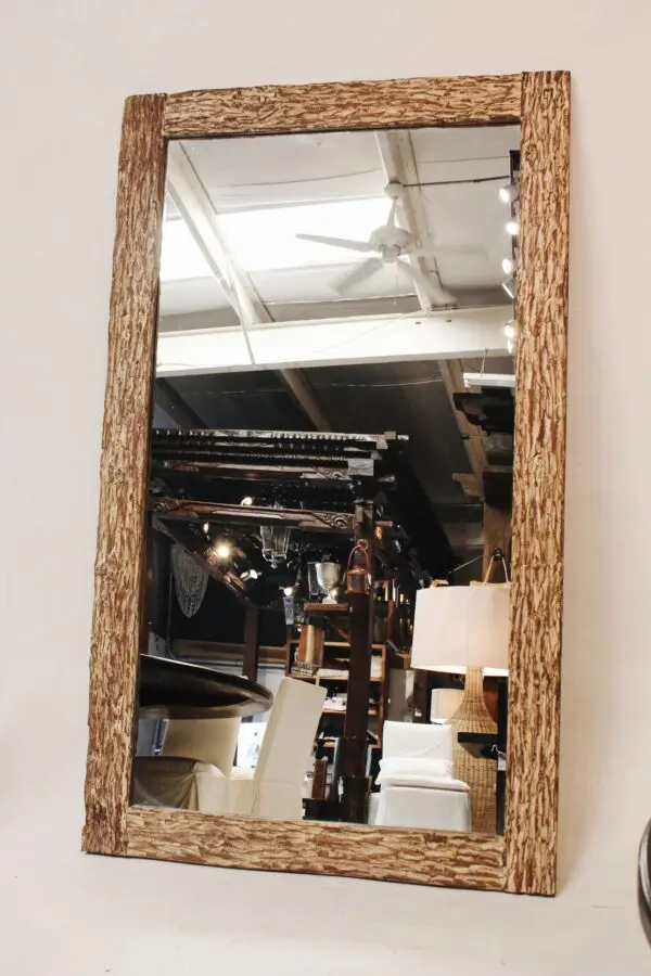 Wood-framed mirror reflecting interior space.