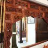 Intricately carved wooden frame and poles.