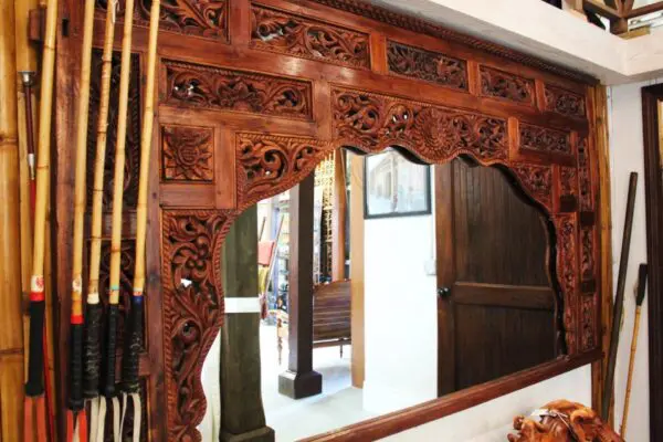 Intricately carved wooden frame and poles.