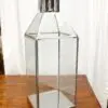 Metal and glass lantern on wooden table.