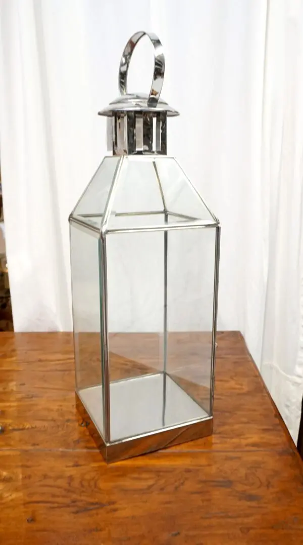 Metal and glass lantern on wooden table.