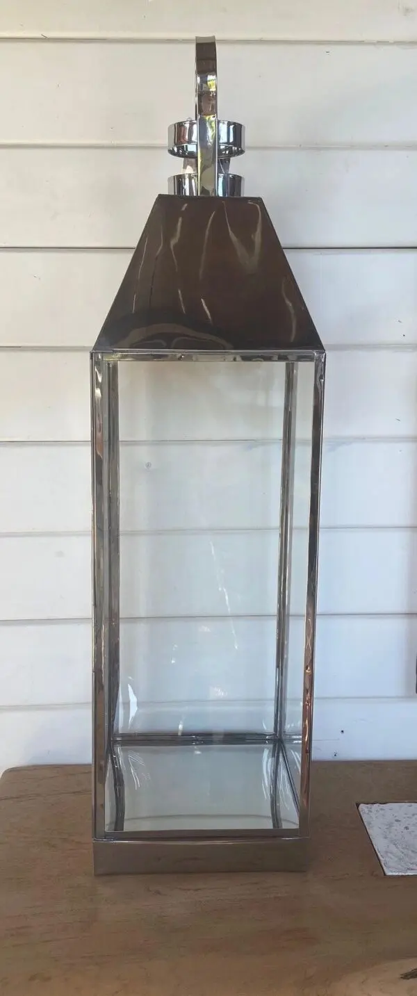 Glass lantern with metallic frame design.