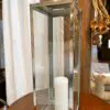 Glass lantern with a white candle inside.