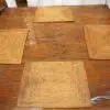 A wooden table with four square plates on it.