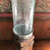 A glass vase sitting on top of a wooden stand.