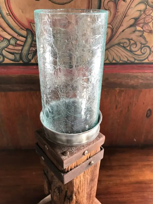 A glass vase sitting on top of a wooden stand.