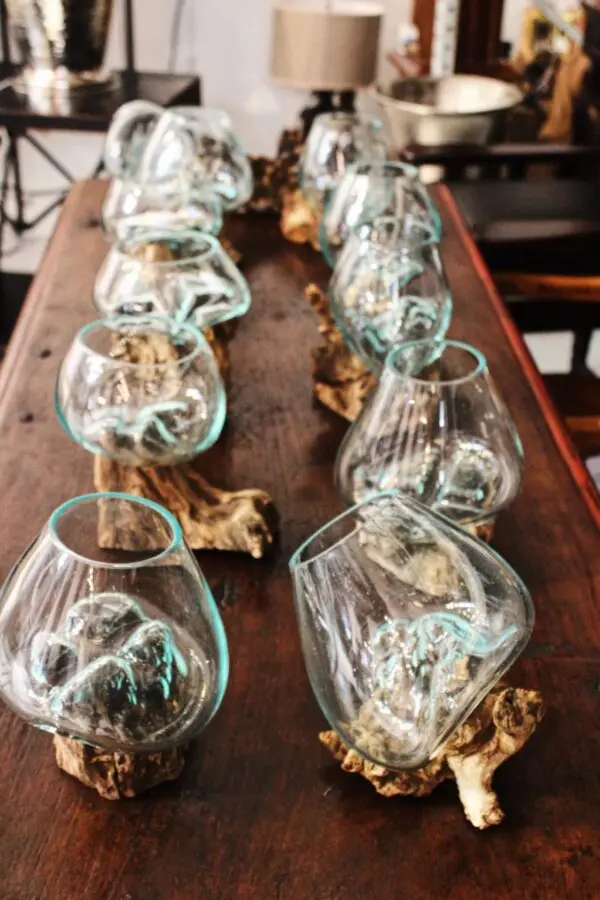 Glass vases arranged on wooden support.