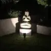 Stone Buddha statue illuminated at night.