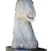 A horse statue sitting on top of a stone slab.