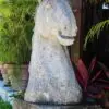 A stone horse statue sitting on top of a rock.
