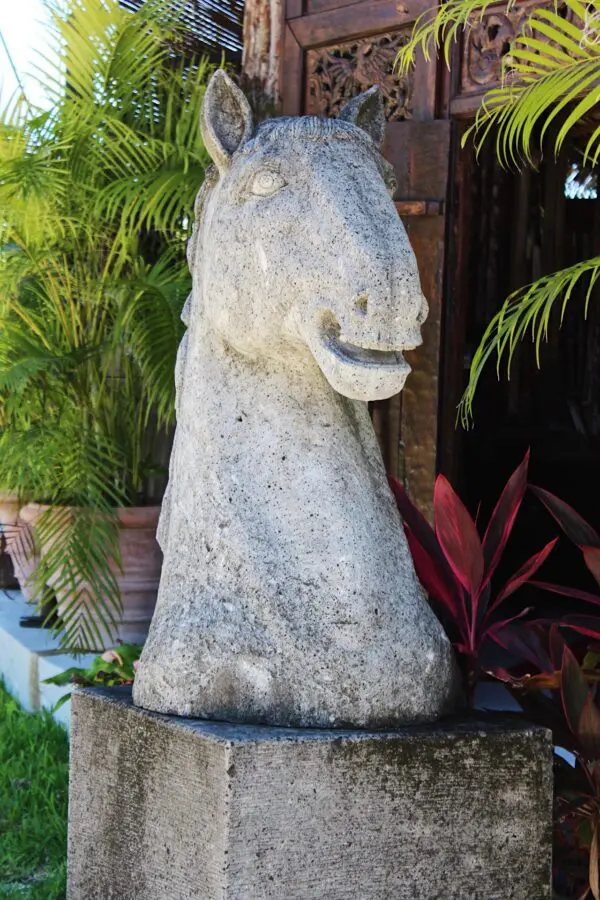 A stone horse statue sitting on top of a rock.