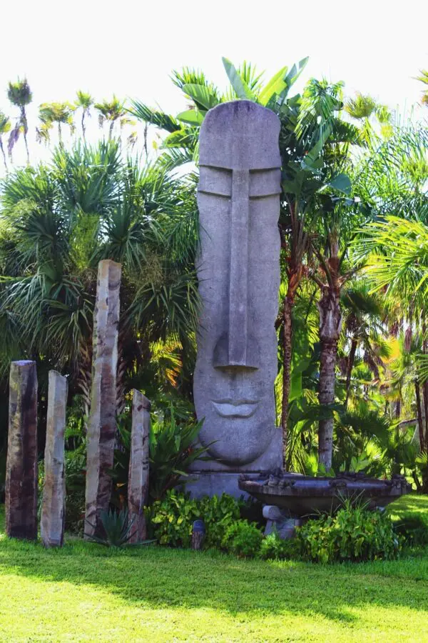 Moai statue surrounded by lush greenery.