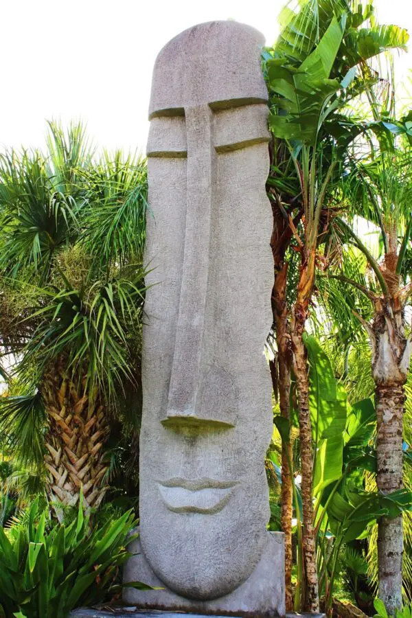 Easter Island statue among tropical plants.