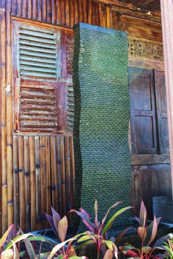 Textured green wall beside wooden structure.