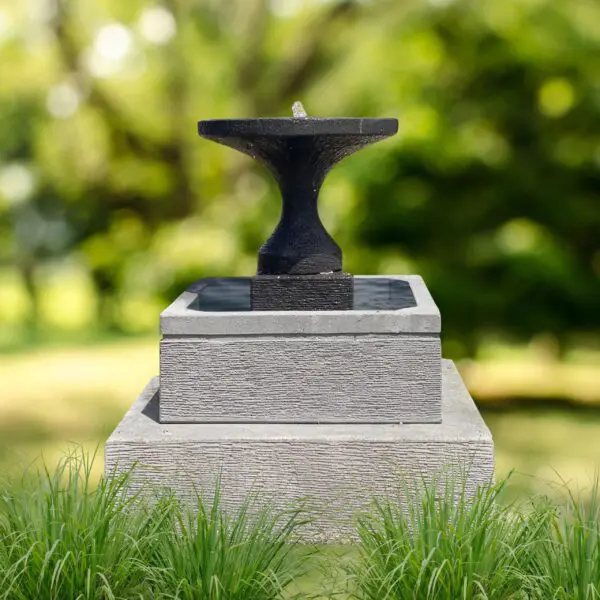 Garden water fountain on stone pedestal.