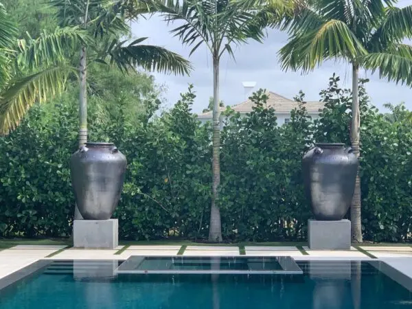 Two large urns beside a swimming pool.