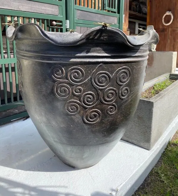 Decorative black pot with swirling patterns.